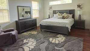 A bedroom with a bed, nightstands, a dresser, a ceiling fan, and a large window. - Countryside Comfort 5 MIN to FAST / WEC & 15 min HITS 1 acre 2 KNG BED Near I-75 (Ocala)