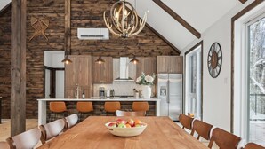 Eine moderne Küche mit Holzelementen, einer großen Kochinsel und einem Essbereich mit Obstschale.