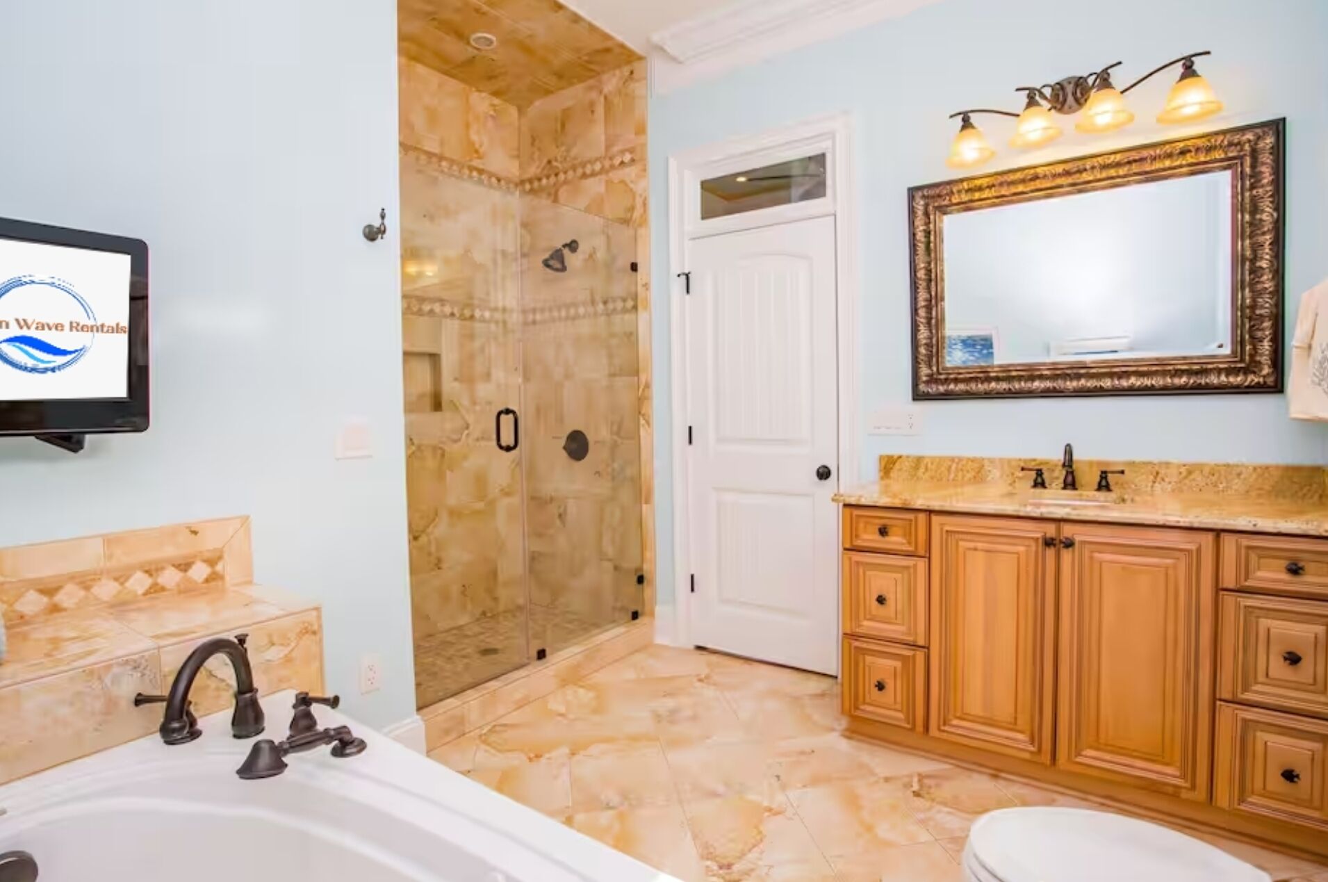 Master bathroom suite with double vanity, tub, and glass shower.