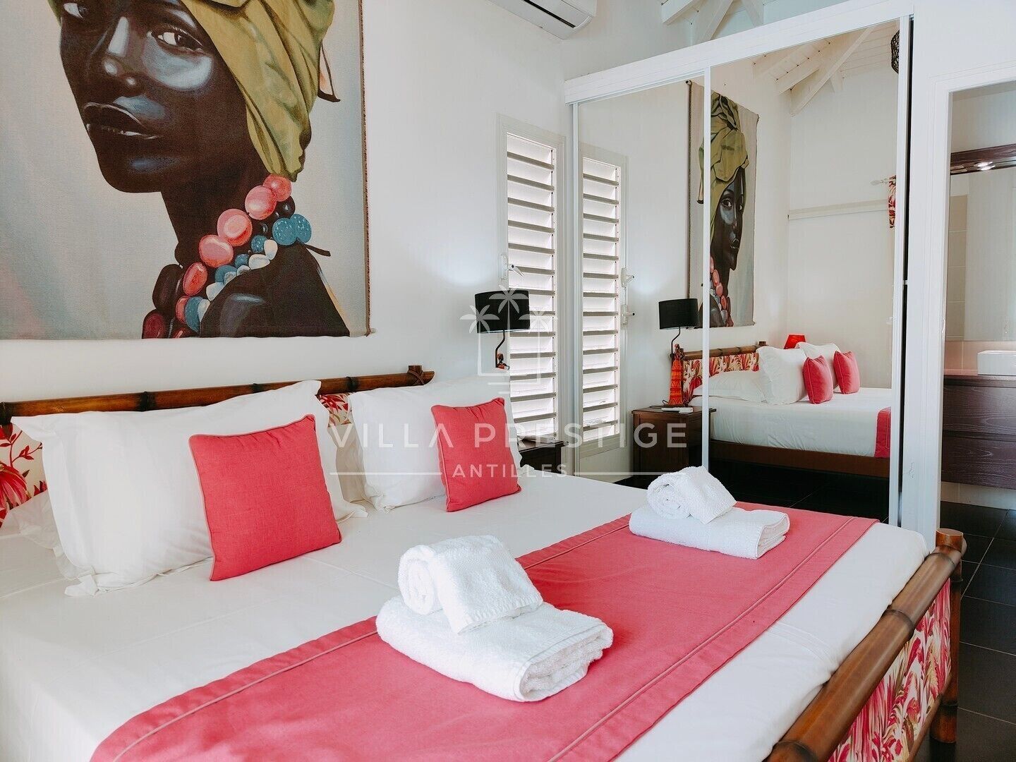 Una habitación de hotel con una cama, un espejo grande y un cuadro en la pared.