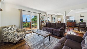 A spacious living area with a sofa, armchair, and a wooden coffee table. - Black Sands Escape- Ocean and Range Views- Comfort (Whitethorn)