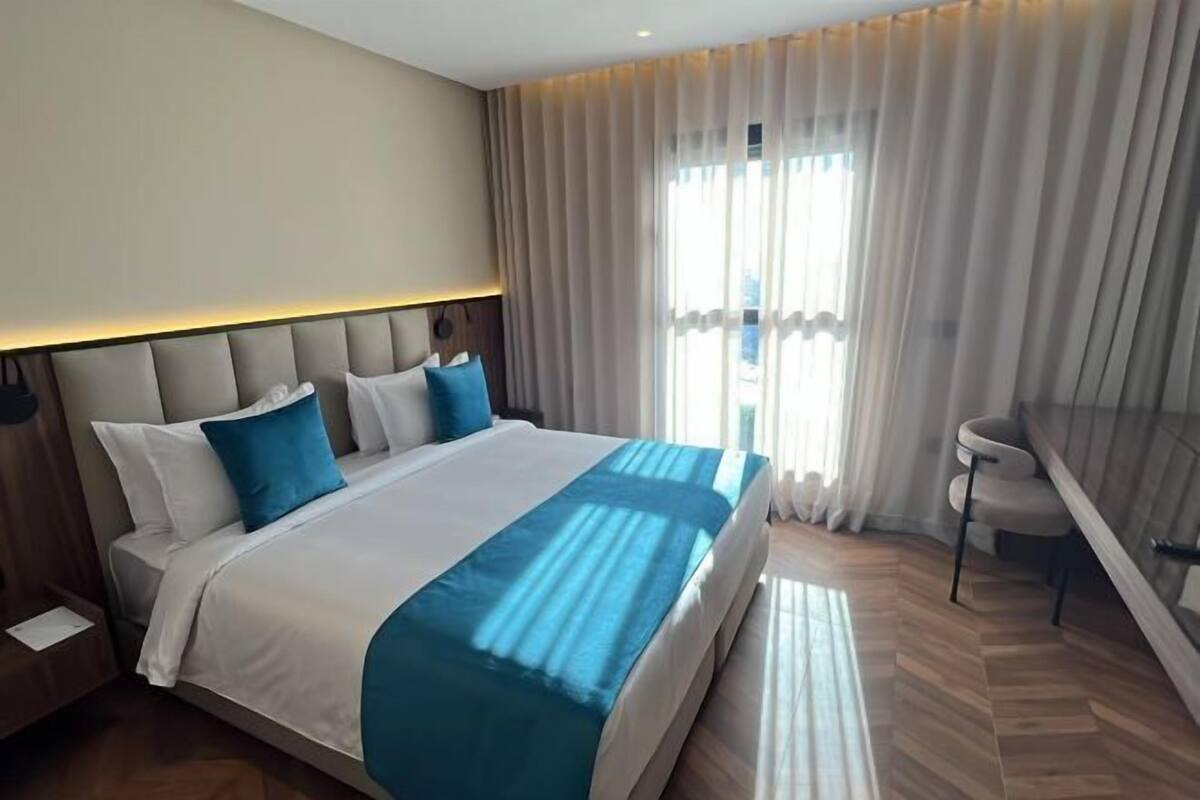 Una habitación de hotel con cama, escritorio y silla.