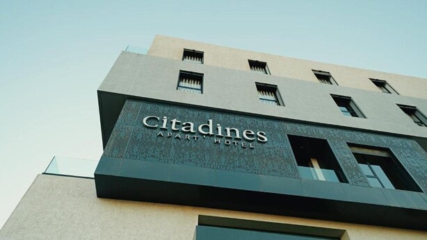 Een modern gebouw met een bord waarop 'Citadines Apartment Hotel' staat.