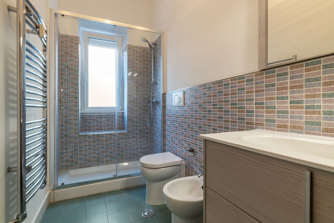 Un baño con ducha, inodoro y lavabo.