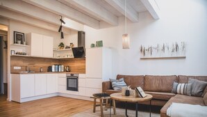 Una cucina moderna con mobili bianchi, piani di lavoro in legno e forno integrato.