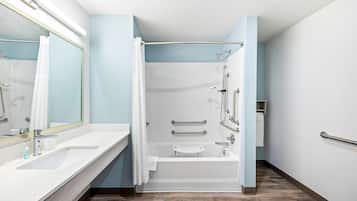 Un baño moderno con ducha, bañera y tocador con espejo.
