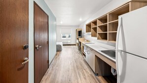 Una cocina moderna con armarios de madera, un refrigerador blanco y un horno empotrado.