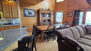 A wooden cabin interior with a dining area, kitchen, and living room. - Spacious Wisp Retreat w/ Views & Game Room (Mchenry)