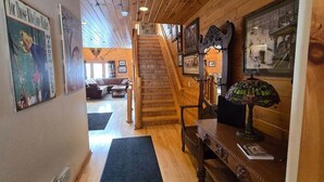 A wooden interior with a staircase, framed pictures, and a lamp. - Spacious Wisp Retreat w/ Views & Game Room (Mchenry)