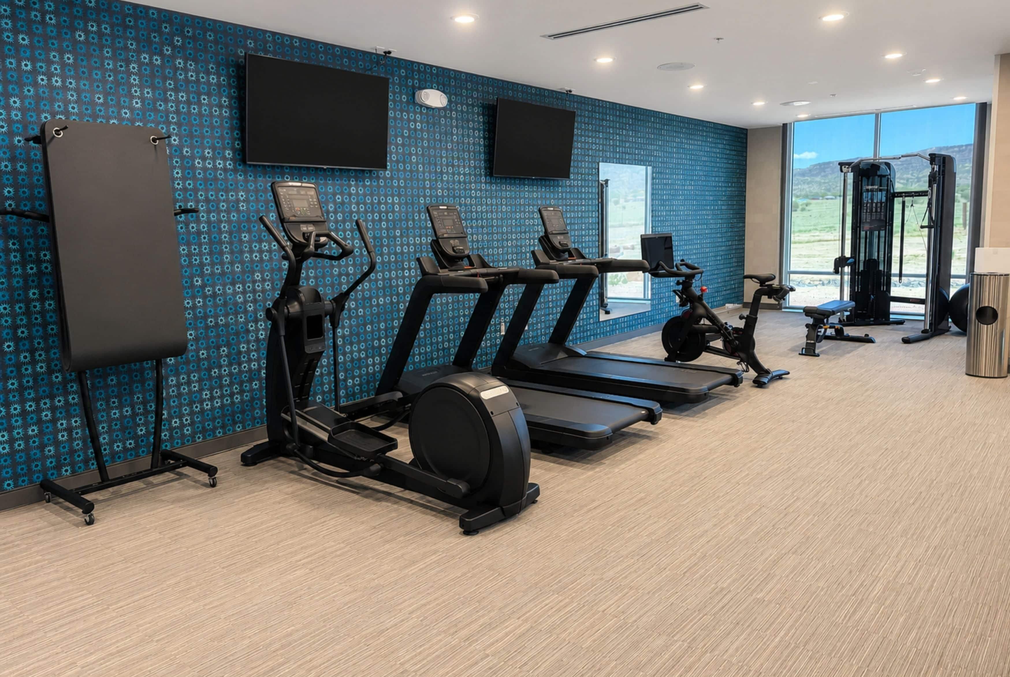 A gym with treadmills, elliptical machines, and a weight machine.