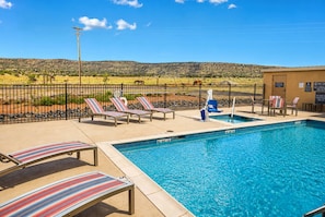 A swimming pool with lounge chairs and a fenced area with a view of a hilly landscape. - La Quinta Inn & Suites by Wyndham Shonto (Shonto)