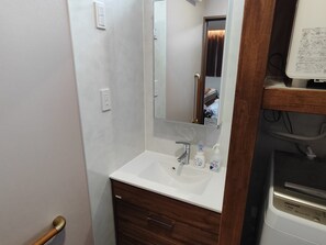 Ein Badezimmer mit Waschbecken, Spiegel und Holz-Waschtisch.