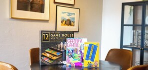 Una mesa con un juego de mesa Game House, el juego Candy Land y una caja de películas Blockbuster.