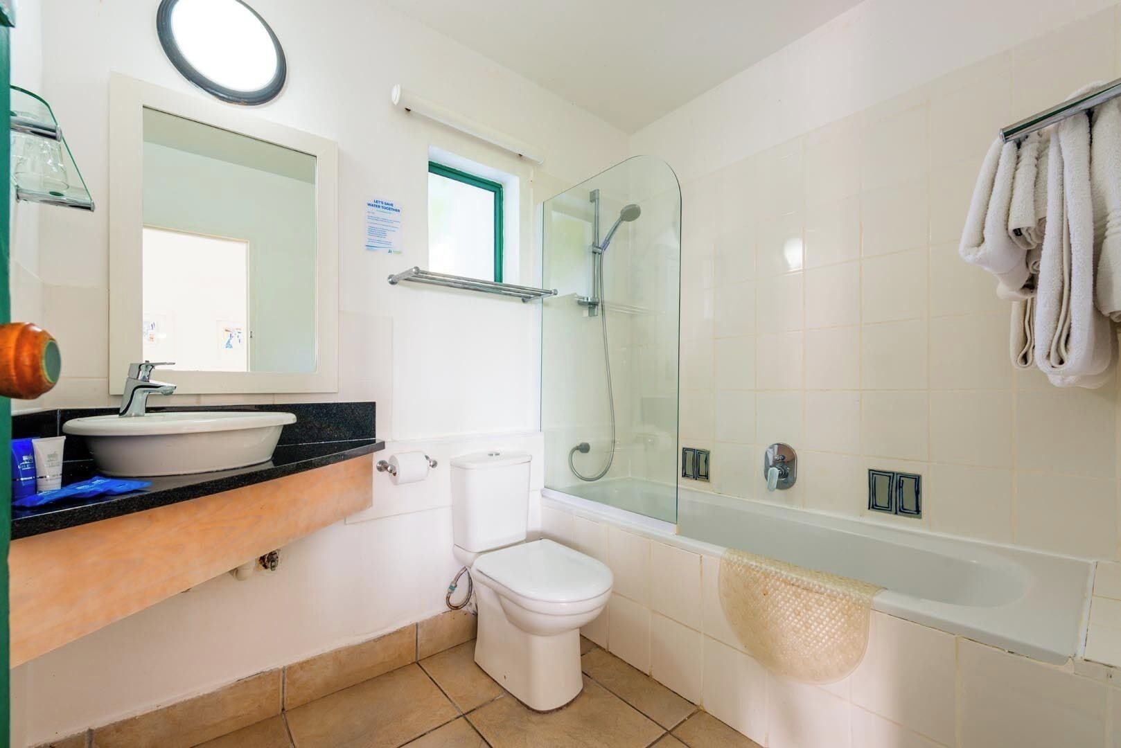 A bathroom with a sink, toilet, shower, and bathtub.