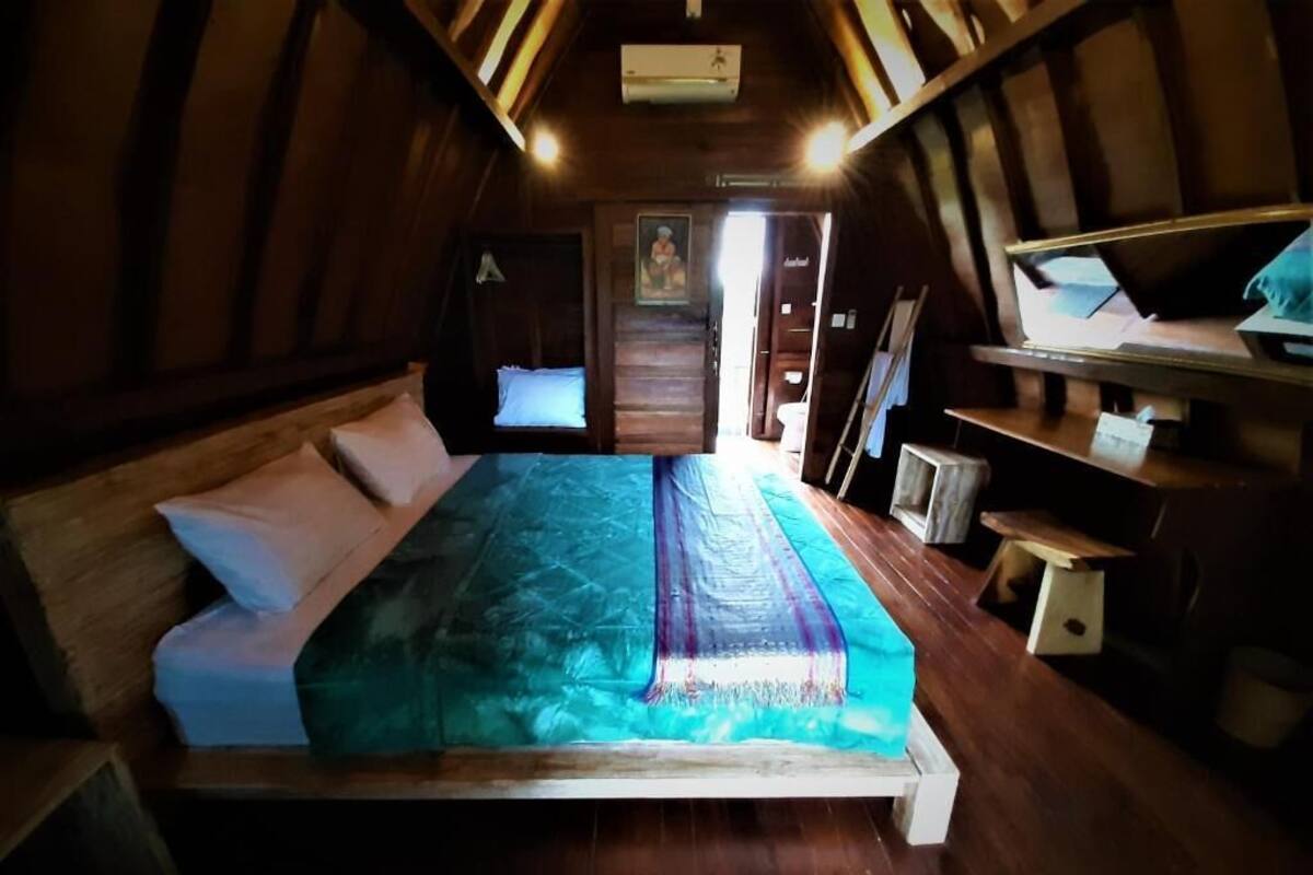 Une pièce confortable avec un lit, des murs en bois et une petite table.