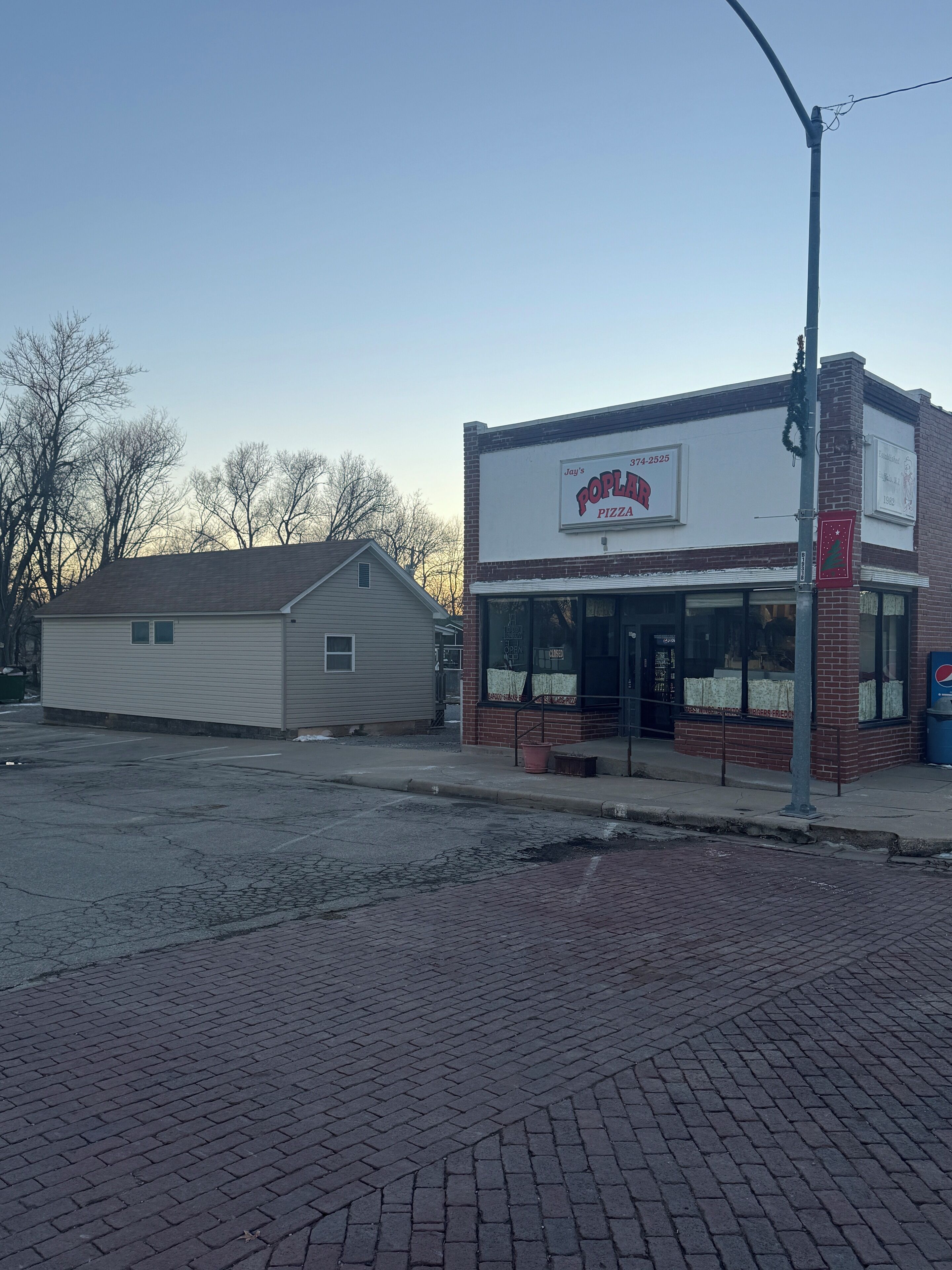 A two-story building with a storefront labeled "Jay's Poplar Pizza."