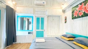 A bedroom with a bed, a window with curtains, a door, and a wall-mounted air conditioner. - Kushak Bungalow Gili Trawangan (Gili Trawangan)