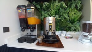 Un espace dédié au café, comprenant une machine à café, un moulin et un récipient rempli de grains de café.