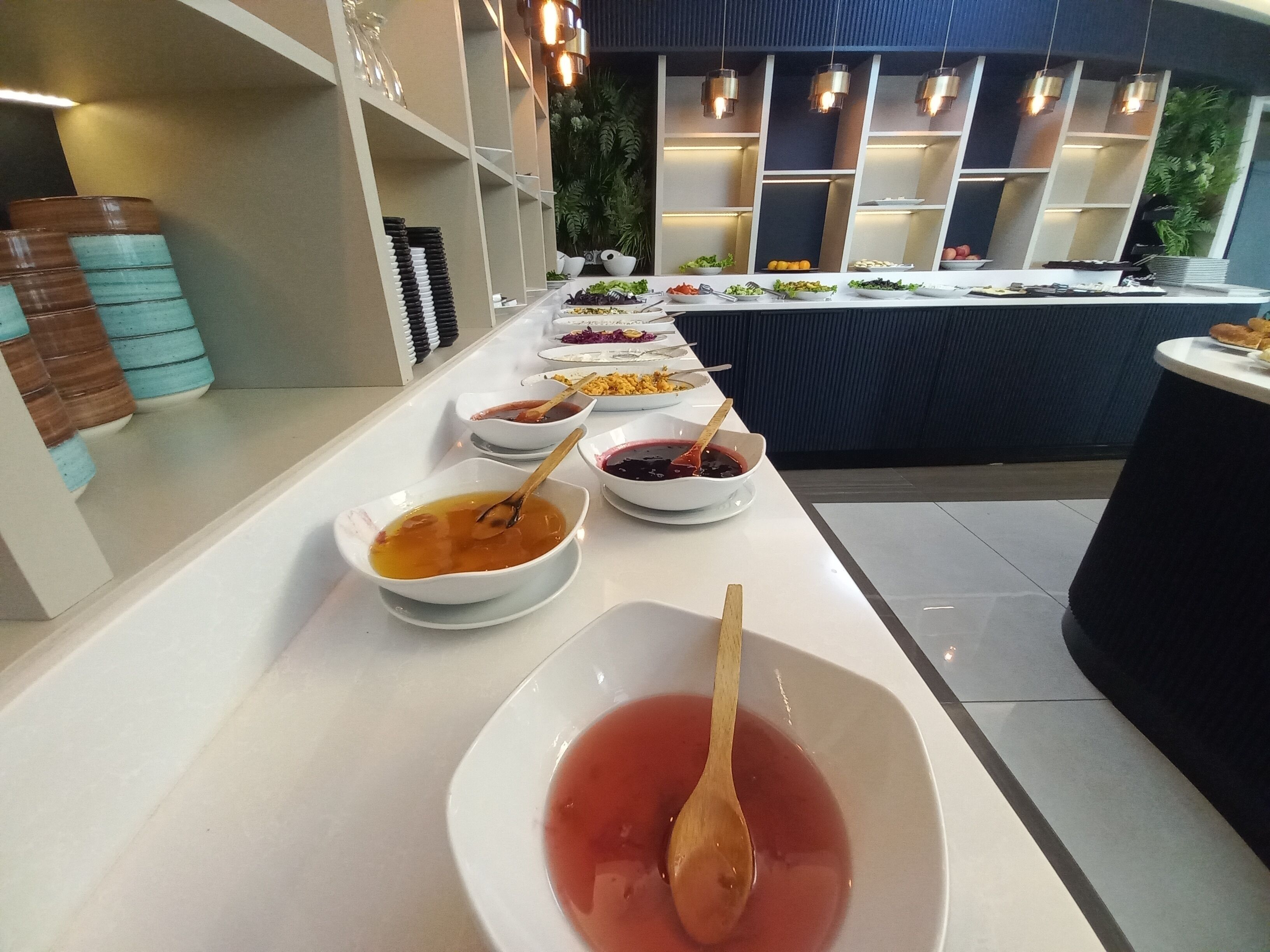 A buffet setup with various dishes and condiments.