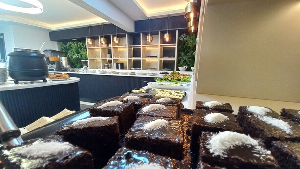 Un buffet proposant une variété de plats, notamment des brownies garnis de noix de coco.