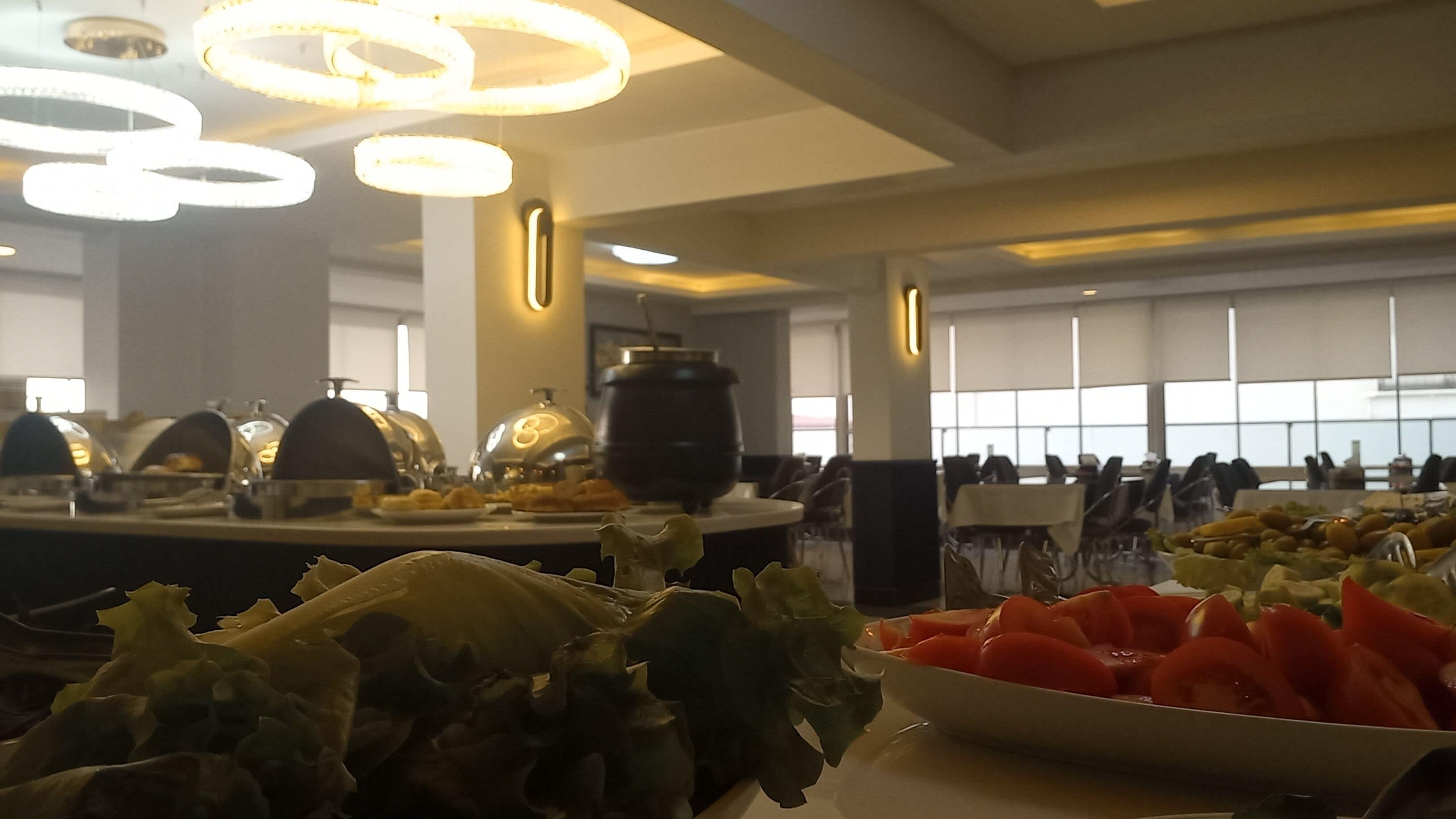 Een buffetopstelling met diverse gerechten en een groot raam op de achtergrond.
