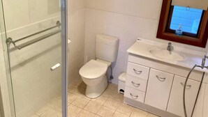 A bathroom with a toilet, sink, and glass shower enclosure. - 15% Off Weekly | Coastal-View Cypress Beach House (Island Beach)