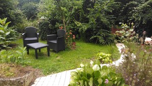 A garden with a seating area featuring two chairs and a table.
