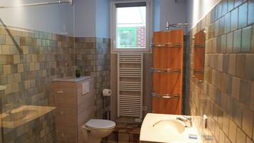 Een douche, een haardroger, handdoeken, toiletpapier