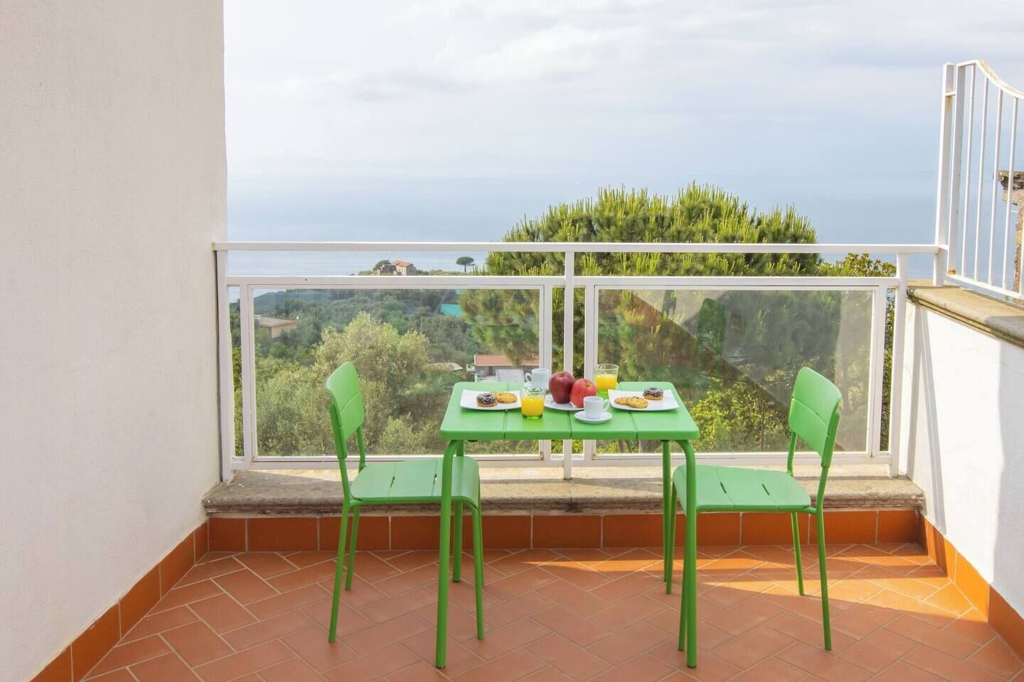 Een balkon met een ontbijtje, met uitzicht op een mooi landschap.