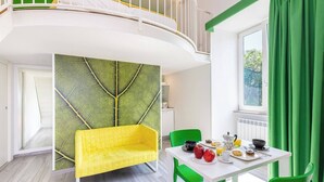 A modern room with a yellow sofa, green chairs, a white table with breakfast items, and a green leaf-patterned wall. - Sorrento Villa With Pool And Amazing Views (Sorrento)