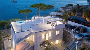 A modern two-story house with a rooftop deck, a swimming pool, and a view of the sea. - Villa By The Beach With Sea-View And Luxury Amenities (Massa Lubrense)