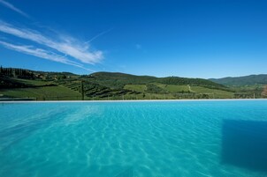 Una piscina al aire libre de temporada, sombrillas, tumbonas