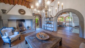 Un salon spacieux avec une cheminée, des meubles en bois et un lustre.