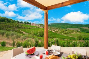 A table set for breakfast with a view of vineyards and a distant building. - Villa Chianti With Pool Near The Vineyard (Greve in Chianti)