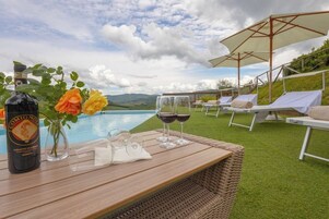 Una piscina al aire libre de temporada, sombrillas, tumbonas