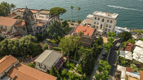 An aerial view of a coastal town with historic buildings, a church, and a beachfront area.
