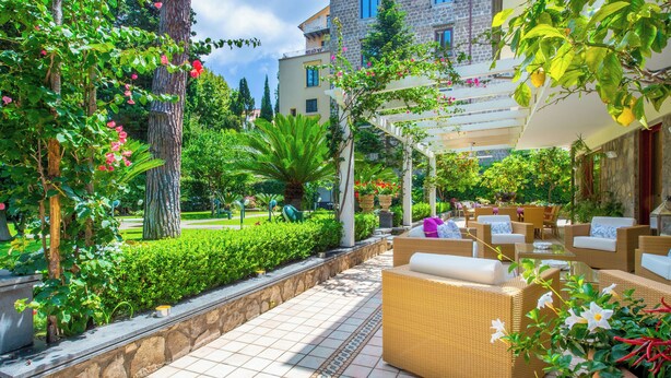 A patio area with wicker furniture and a stone pathway.