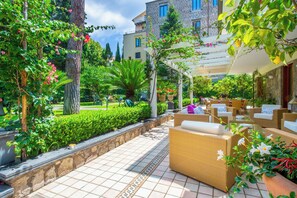 A patio area with wicker furniture and a stone pathway.
