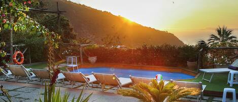 Utomhuspool, parasoller och solstolar