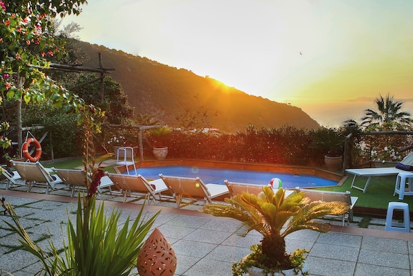 Piscine extérieure, parasols de plage, chaises longues