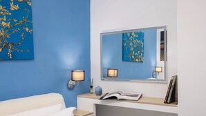 A bedroom with a bed, bedside table, lamp, and a mirror. - Brezza Marina-Authentic Sorrento Flat By The Beach (Sorrento)
