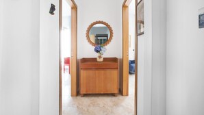 A hallway with a wooden dresser, a mirror, and a vase of flowers. - New Family 3 Bedrooms House In Sorrento (Sorrento)