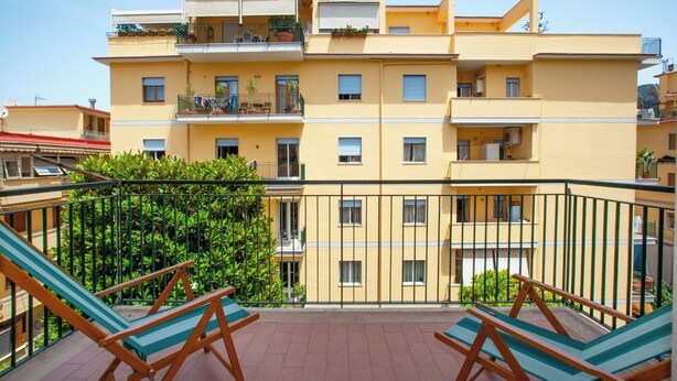 A multi-story residential building with balconies, a tiled terrace, and outdoor furniture. - New Family 3 Bedrooms House In Sorrento (Sorrento)