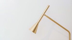 A gold-colored floor lamp with a curved arm and a conical shade. - Exclusive Suite With Terrace By Sorrento Main Square (Sorrento)