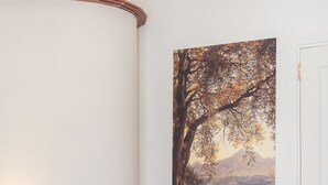 A room with a bed, a chair, a painting, and a door. - Luxury New Sorrento Home With Terrace - Sleeps 12 (Sorrento)