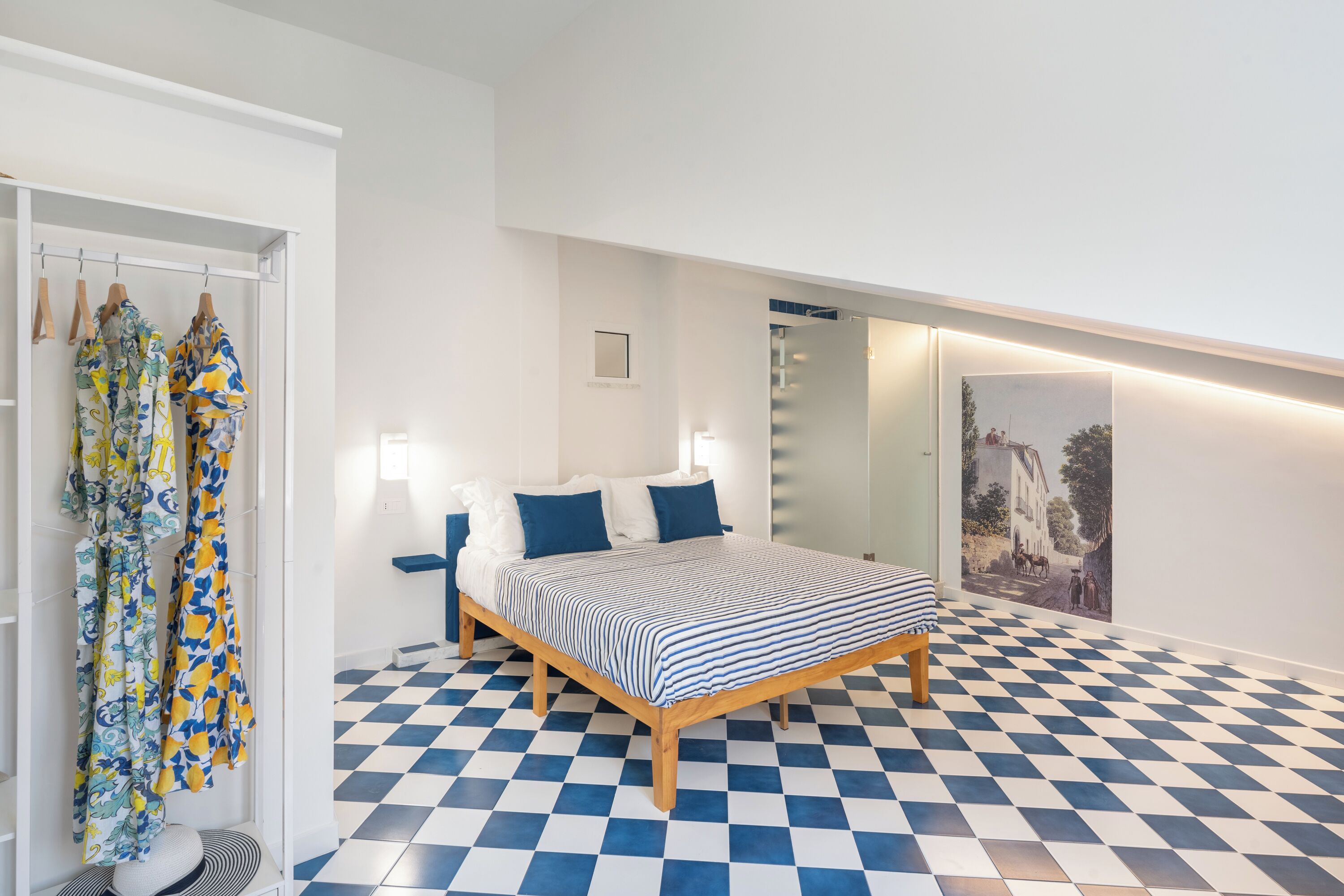 A bedroom with a checkered floor, a bed with a striped bedspread, and a painting on the wall.