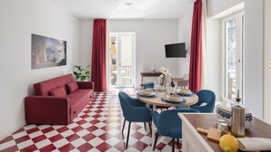 A modern living room with a red sofa, blue chairs, a dining table set, and a checkered floor. - Lux Family Home In Sorrento With Terrace/Solarium (Sorrento)