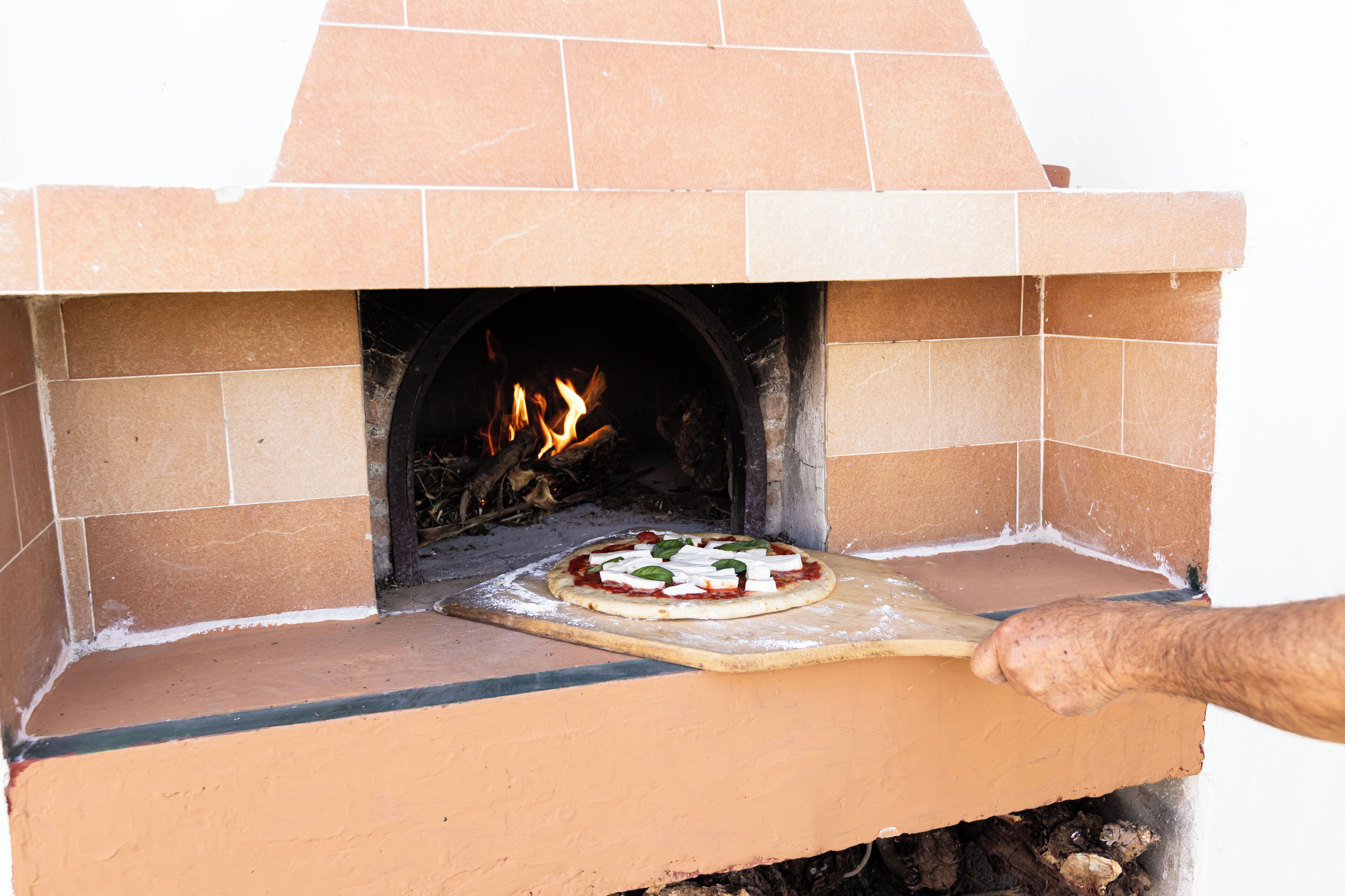 A pizza being cooked in a brick oven.