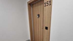 A hallway with a wooden door marked with the number 151, a doormat, and a tiled floor. - Cozy 1-bedroom apartment in lovely Warszawa with WiFi (Warszawa)