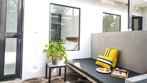 Une chambre moderne avec un banc, une plante en pot et un plateau de pâtisseries.